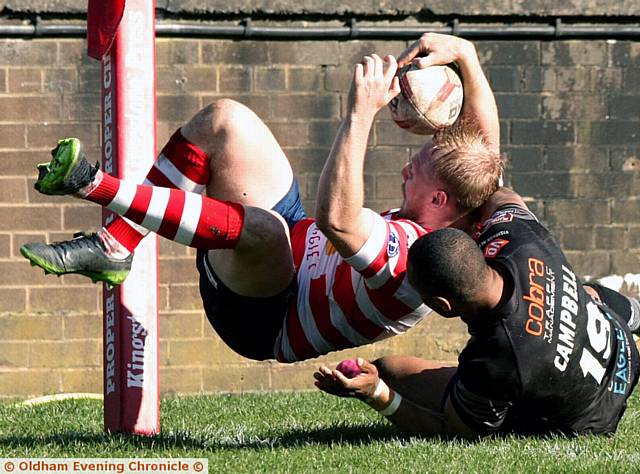 CLOSE . . . Oldham's Scott Leatherbarrow is held up near the line by Johnny Campbell