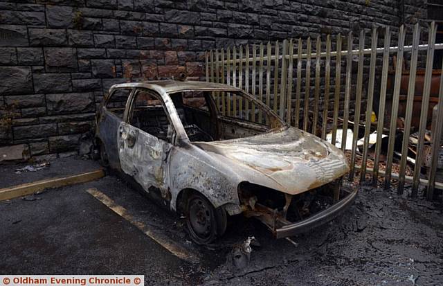 BURNED OUT . . .  the shell of a car after the oil blaze.