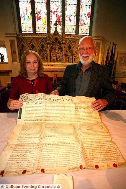 CELEBRATION . . . Hilary Saxon, of the church council, Stephen Whitehead, trustee of the Saddleworth museum, with the deed to the church from 1748, to the first curate of St John's, Richard Hopwood