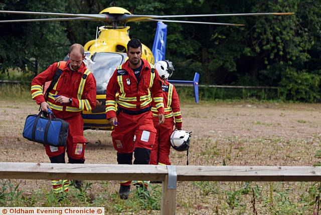 MEDICS dash from the helicopter air ambulance which touched down in Oldham town centre