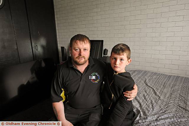 UNHAPPY . . . Neil, pictured here with one of his sons, Cole, says the family are effectively living upstairs