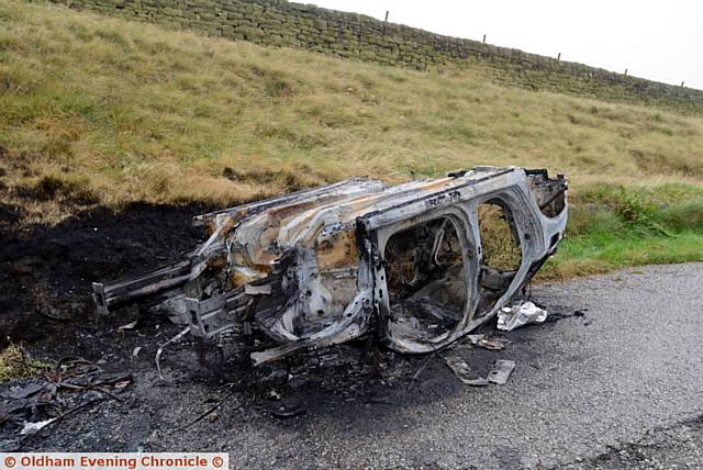 The burnt-out shell of a car left on Huddersfield Road, Denshaw near New Years Bridge Reservoir.