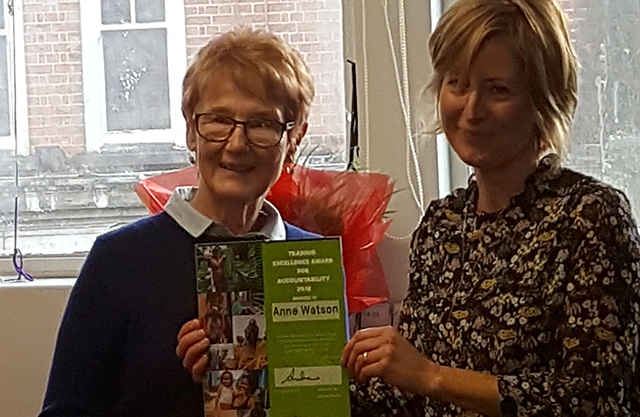 Anne Watson receives her award from Oxfam's Head of Retail Jane Randrup