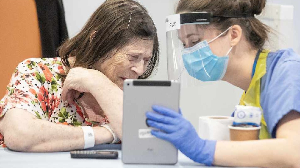 Patient Sandra Navin is helped to make a video call with her family by Laura Wade. Laura normally works as a dentist but is now supporting patients at the NHS Nightingale Hospital North West as a member of the Family Liaison Team