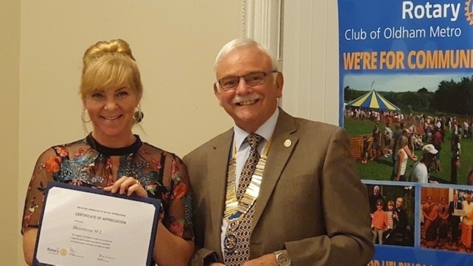 Jessica Moreland, President of Dovestone WI, receives the coveted honour from Garvin Crabtree, president of Rotary Oldham Metro