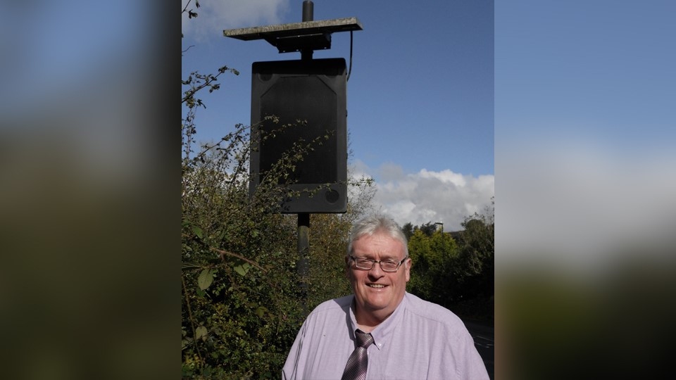 Councillor Howard Sykes pictured by a VAS sign on Buckstones Road