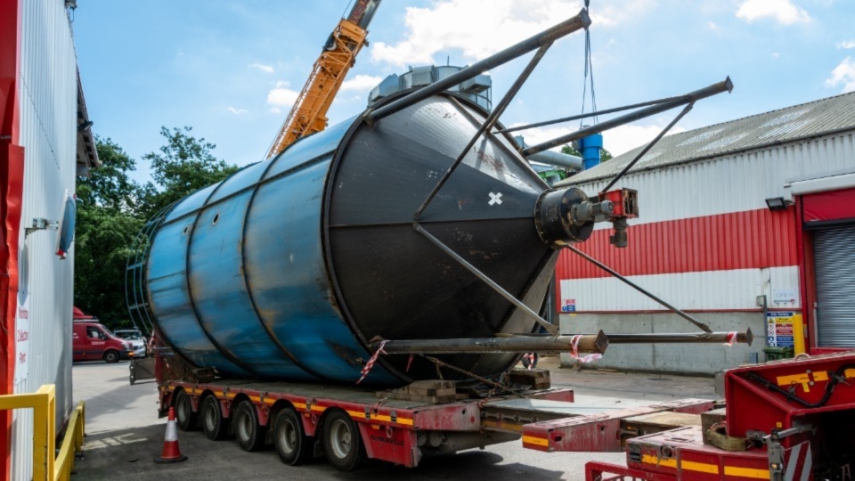 The redundant silo is taken away for scrap