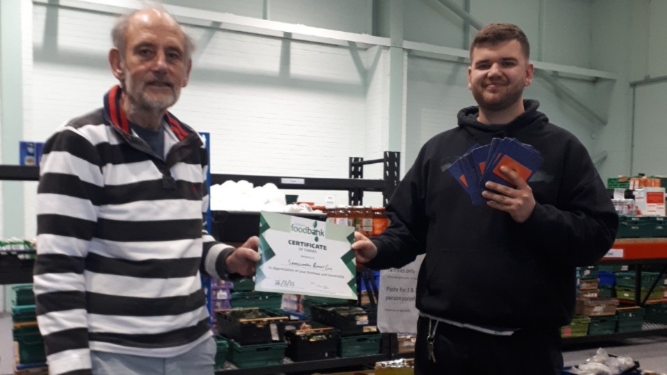 Saddleworth Rotary Club President Ian Brett and Foodbank Manager Tom Lewis-Hood accepting £500 worth of Aldi vouchers on behalf of the Foodbank