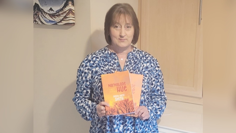 Oldham author Donna Marie Smith shows off a copy of Marmalade Hue