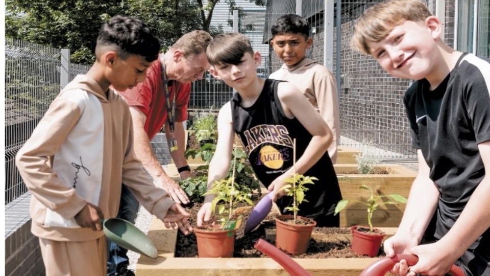 Children from a Mahdlo holiday club learn to grow and cook food in raised beds