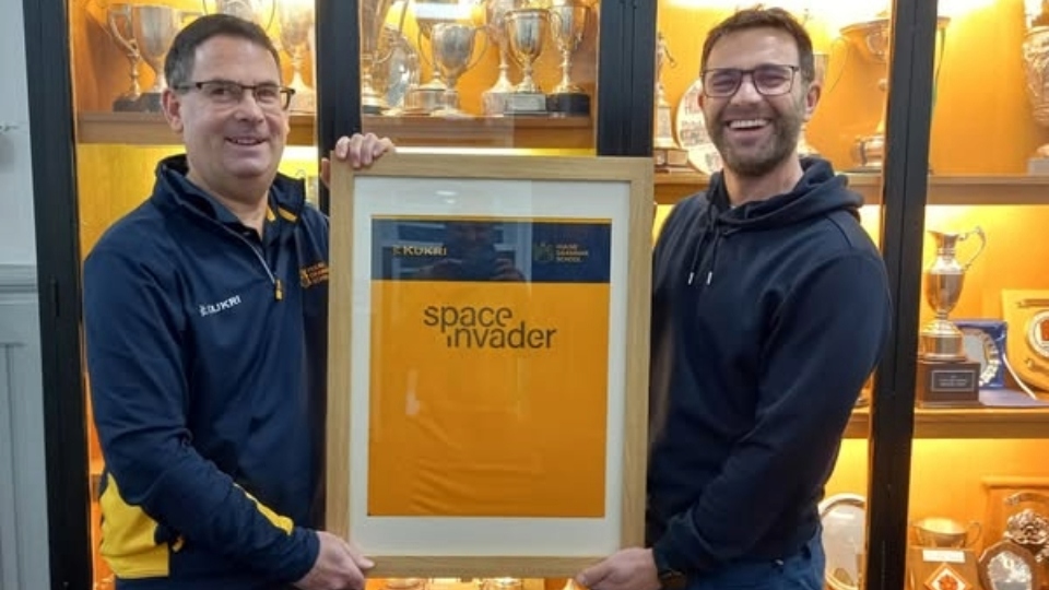 Former pupil John Williams (class of 1991, right) and founder of SpaceInvader is pictured with Hulme Grammar School Director of Sport Gus Hurst with this year's brand new football shirt