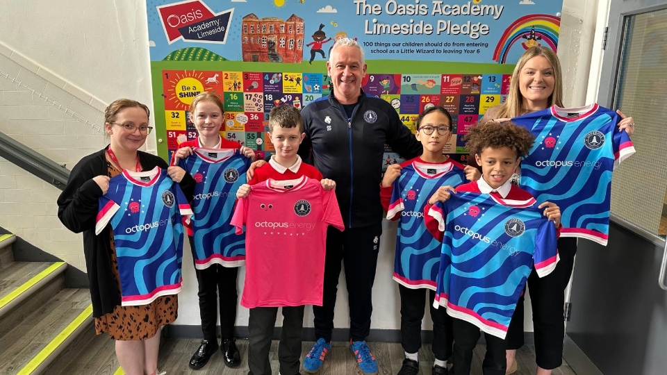 Oasis Academy Limeside children proudly show off their new kits. Pictured are (from left): Danielle Burns (Operations Manager), Millie Cahill, Maxwell Beaumont, Uppermill FC CEO Steve Southern, Lexi Mei Gao, Mchenry-Junior Okere and Hannah Bolton (Assistant Principal)