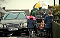 A tight squeeze for children, parents and buggies as they attempt to get past cars on the pavement.
