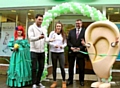 St Helens Super League player Mark Flanagan cuts the tape, assisted by swimmer Jessica Fullalove and store director Nigel Williams.