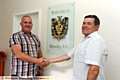 HAPPIER TIMES: former Borough chairman Mark Kilgannon (left) is welcomed to Mossley’s Seel Park by Lilywhites director Steve Tague last summer.