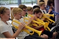 Primary school pupils perform in a brass band concert (with plastic instruments) at Mossley Hollins High School.