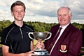 IT’S MINE . . . Matthew Kay receives the District Championship trophy from Brookdale captain Phil Forshaw.