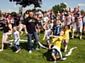 OFFICIALLY open...Kenny Heaton and local youngsters run through the ribbon