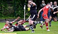 OVER WE GO . . . James Whalley dives in to put Saddleworth Rangers ahead against Kells