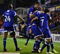 CELEBRATION TIME . . . Lee Erwin is mobbed by his Athletic team-mates after scoring