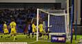 DID THE BALL CROSS THE LINE? . . . Freddie Ladapo's header bounces down off the crossbar in the 89th minute against the Dons, but appeals for a goal were waved away
