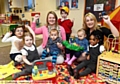 OUTSTANDING news . . . Simon’s House Nursery celebration with manager Susie Mortin (left) and Victoria Burke with some of the children