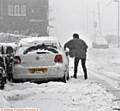 A DRIVER clears her car of snow on Doctor Lane, Scouthead