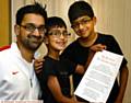 HASSAN Sajid (centre) with his winning poem about his brother Raihaan (right) and proud father Sajid Iqbal