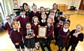 OUTSTANDING . . . head teacher Elizabeth Travis (back left), deputy head Deborah Hodgin (back right) and pupils show off the letter from Schools Minister Nick Gibb