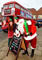 SANTA with his elves, alias Kate Elliott and James Hedges, beside the Christmas crafts bus. Photo Chas Breton
