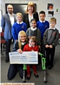 MAKING a wish come true . . . Olivia Berry and mum Christie Kindon receive the donation. Back, from left, Rais Bhatti (head of school, Yew Tree), Eleanor Riley (Mather Street), Sally Brown (head of school Mather Street), Hannah Ahmed (Yew Tree), Nico O’Reilly (Mather Street) and Liam Vickery (Yew Tree)