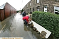 STEM the tide: residents battle against the elements in Delph New Road, Delph, as the floods threaten to take hold