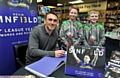 STAR SIGNING: Kevin Sinfield pens a message in his new book at Waterstones in Spindles, flanked by young fans Peter White and Buckley Kershaw, both of whom play for the ex-Leeds Rhinos star’s former amateur club Waterhead at under-10s level.