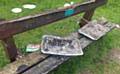 BARBECUE trays discarded on a memorial bench