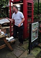 PAUL CLEGG reglazing a phone box - the defib's new home