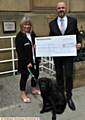 Cathy Dore (Dogs for Good) and Mark Higginbottom (Chairman of Lyceum Theatre) and Zeb the dog, a puppy in training.
