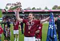 FORMER Athletic star Zander Diamond lifts the League Two title trophy