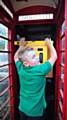 Teddy Royle (10) installs defibrillator in former phone box in Ladcastle Road Dobcross