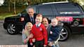 ARRIVING in style . . . Liam Kearney with head teacher Andrew Clowes (left), his mum Felicity, dad Daniel and little brother Charlie