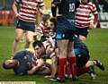 CRASHING HOME . . . Phil Joy of Oldham (centre) gets over the line. 
