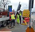 SCENE . . .Workmen repair the traffic lights on Broadway