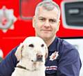 BOWING OUT . . . Lucy with dog unit manager Mike Dewar of Greater Manchester Fire & Rescue Service