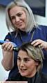 CLOSE SHAVE: Teaching assistant Amy Williams gets to work on Sarah Mossop's locks