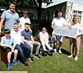 CHEQUE . . . Kevin Longdon presents a cheque to Sarah Horsfield manager of Franklin House, watched by members of Paula White's family and bike riders as well as care home resident Mary Race
