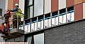 Micro flats on Rhodes Street, Oldham. Cladding being removed by workmen.