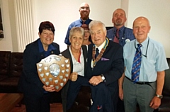 Oldham Rotary Club President Derek Berryman, and Community Service Chairman Ray Coverley, present the Community Shield to Tesco Community champions Rose Knipe, Suzette Wright, Bridget Miller, Mike Milenko and Greg Barratt