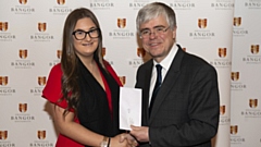 Liberty Kwai Wilcox is pictured receiving an award from Professor Iwan Davies, Vice-Chancellor of Bangor University