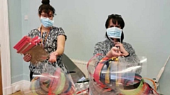 Julie Dowling (right), Practice Manager at Peterloo Medical Centre, takes delivery of the PPE from a staff member at the Middleton Technology School