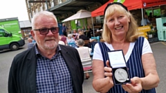 Andrew Kilburn, Chair of Emmaus Mossley, and artist Tonie Rigby with her medal