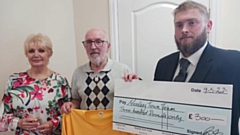 Funeral Director Ben McCutcheon presents a cheque to the Mossley Town Team